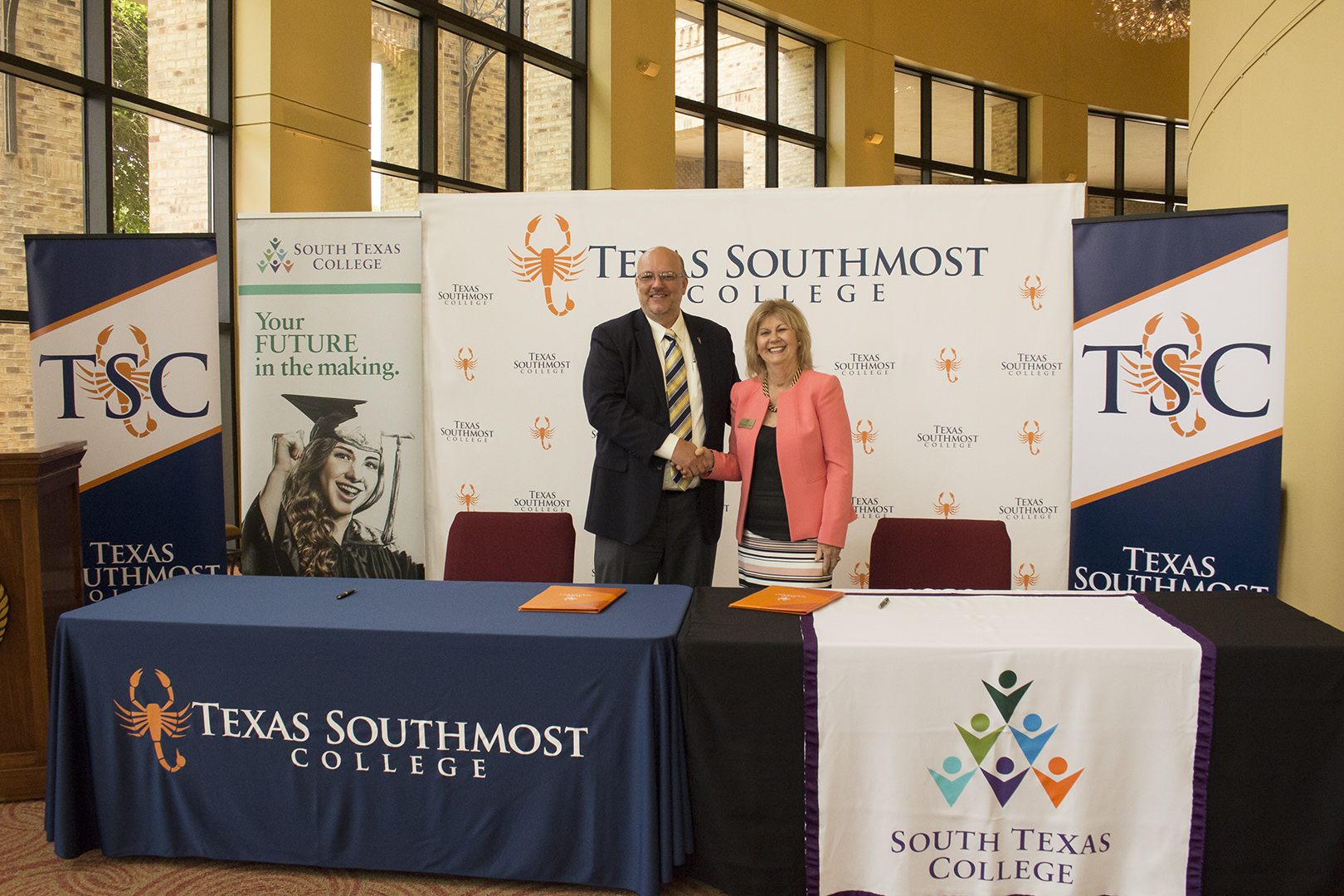 Texas Southmost College (TSC) Interim President Mike Shannon and South Texas College (STC) President Shirley A. Reed shake hands after signing an articulation agreement on July 10, 2017 at the TSC Arts Center in Brownsville, Texas.