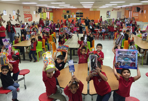 Students hold up the gifts they received during Texas Southmost Collegeâ€™s Angel Tree Toy Drive distribution on Dec. 16, 2015 at the Reynaldo Longoria Elementary School.