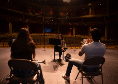 Trumpet students practicing with sheet music on stage at the TSC Performing Arts Center as part of the Mariachi Summer Camp.