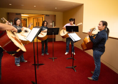 Students running through a guitarron lesson curated by a skilled clinician at the TSC Mariachi Summer Camp.