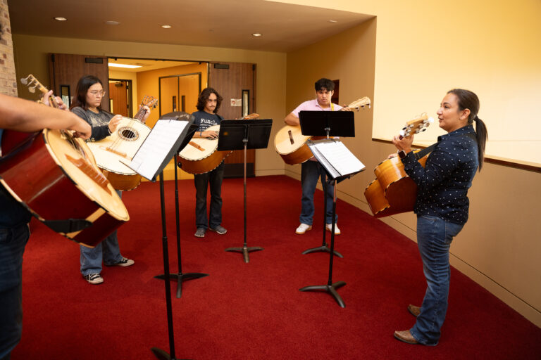 Students running through a guitarron lesson curated by a skilled clinician at the TSC Mariachi Summer Camp.