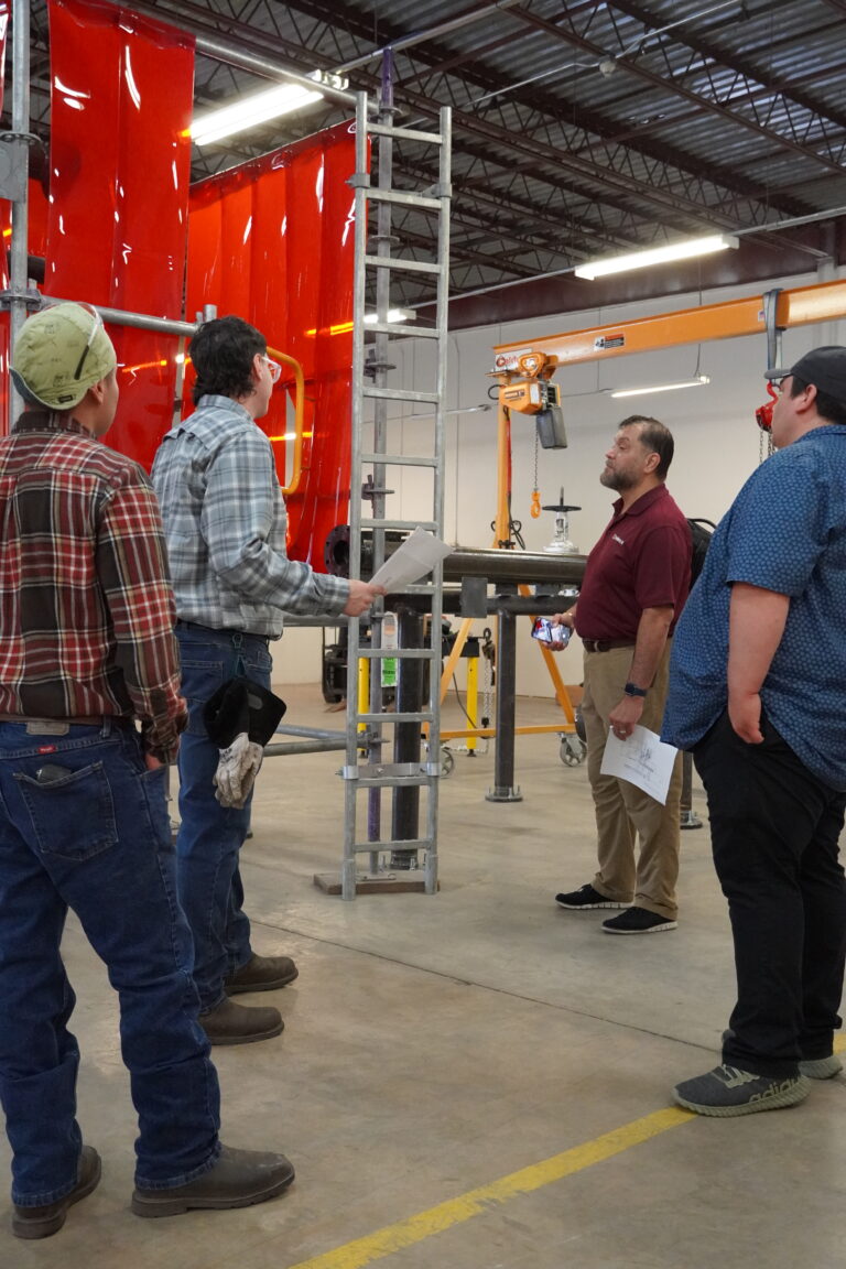 Pipefitting instructor David Garcia gives DFG Solutions representatives of the training facilities used by students in the pipefitting and welding programs.