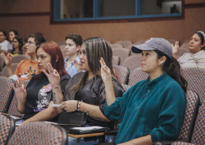 Students in the audience demonstrate a sign shown to them during their session