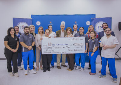 Steven De la Garza and TSC Board of Trustees Chair Adela Garza proudly display the check along with instructors and students in TSC's Nursing program.