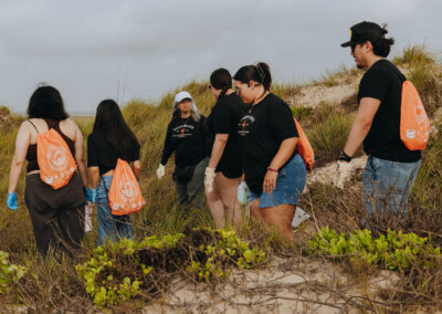 TSC students collect trash along the shoreline at Edwin King Atwood Park during a South Padre Island beach cleanup.