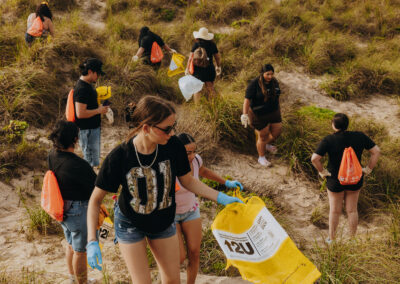 TSC students collect trash along the shoreline at Edwin King Atwood Park during a South Padre Island beach cleanup.