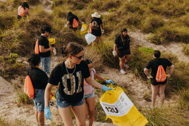 TSC students collect trash along the shoreline at Edwin King Atwood Park during a South Padre Island beach cleanup.
