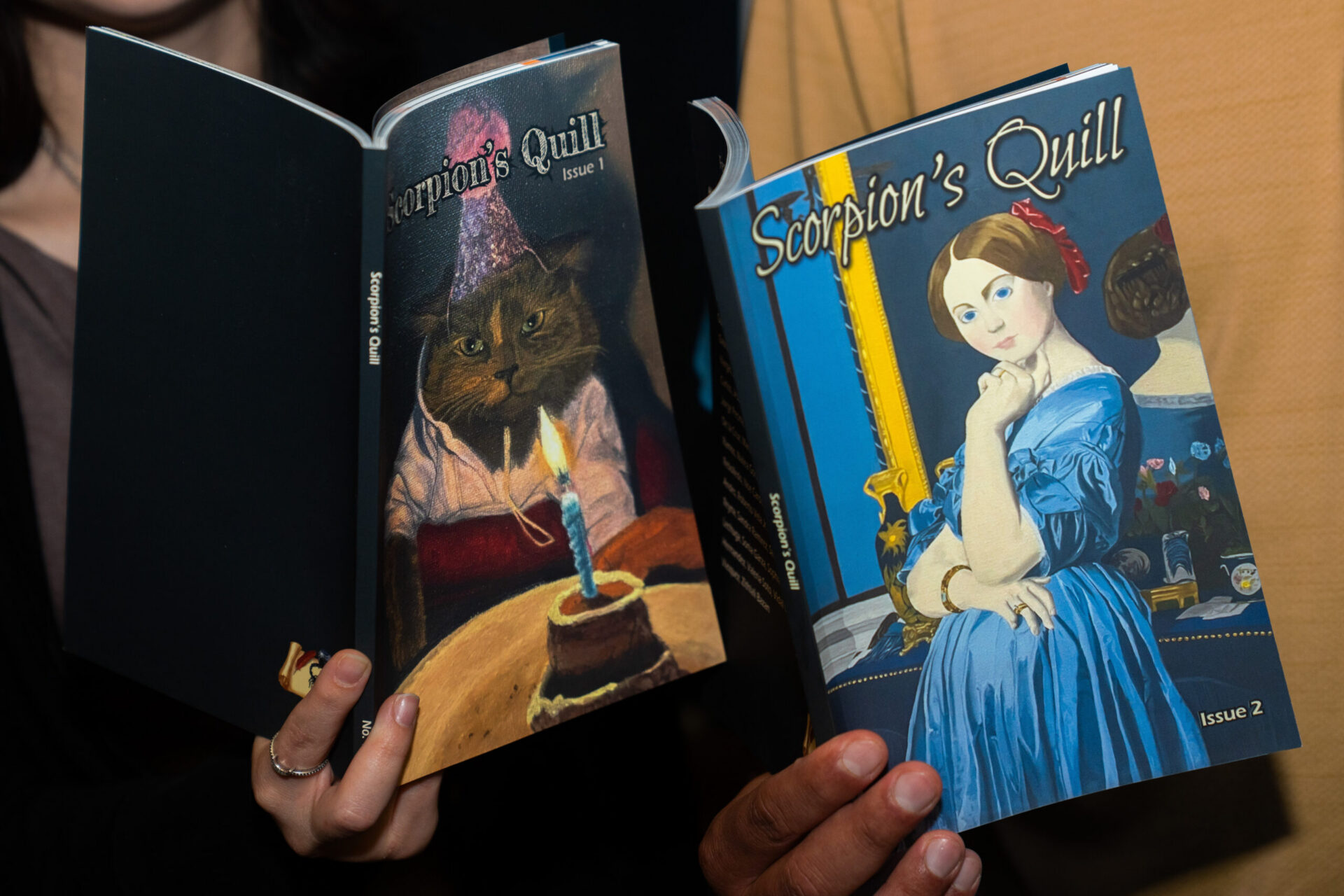 Guests hold copies of Scorpion’s Quill, Issues 1 and 2, during a showcase for the student literary and arts journal at Texas Southmost College.