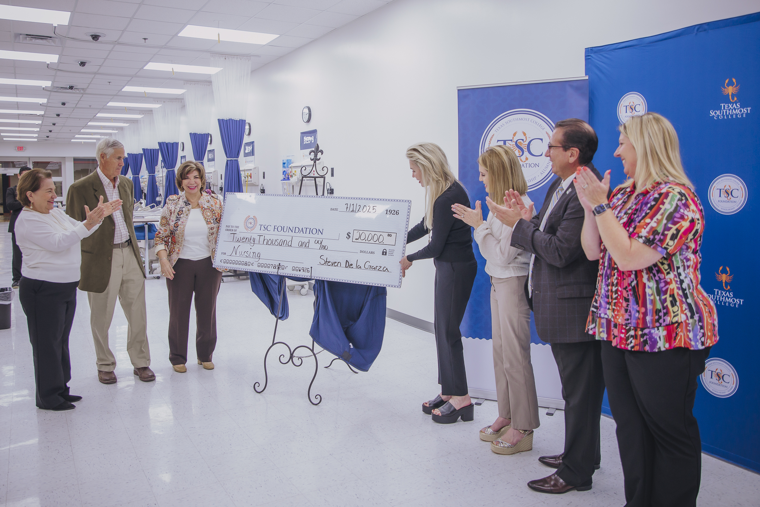 The donation check is unveiled by gathered administration.